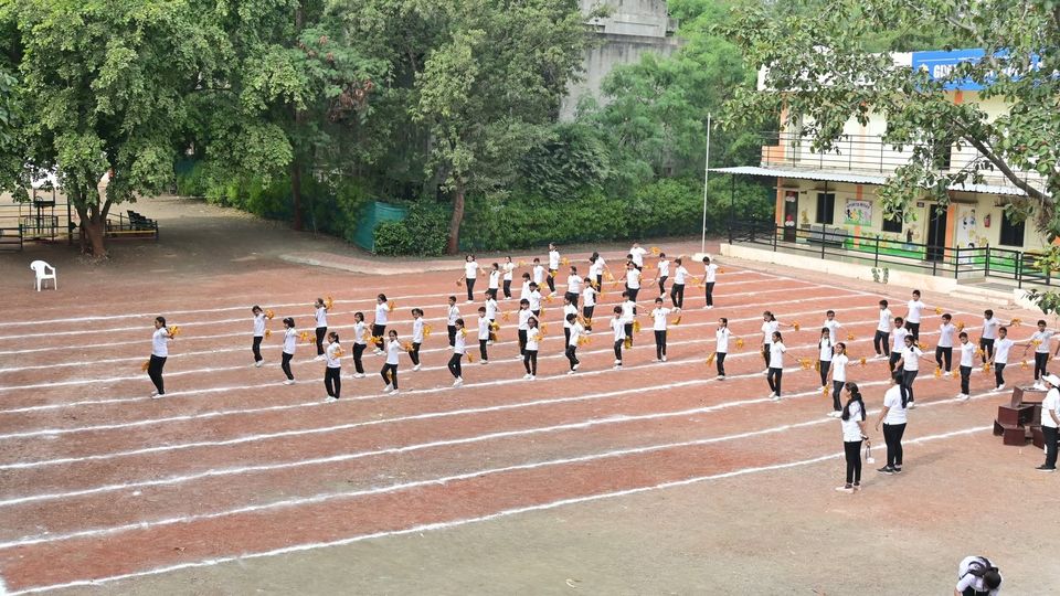 Students in a drill display on the school ground under the trees