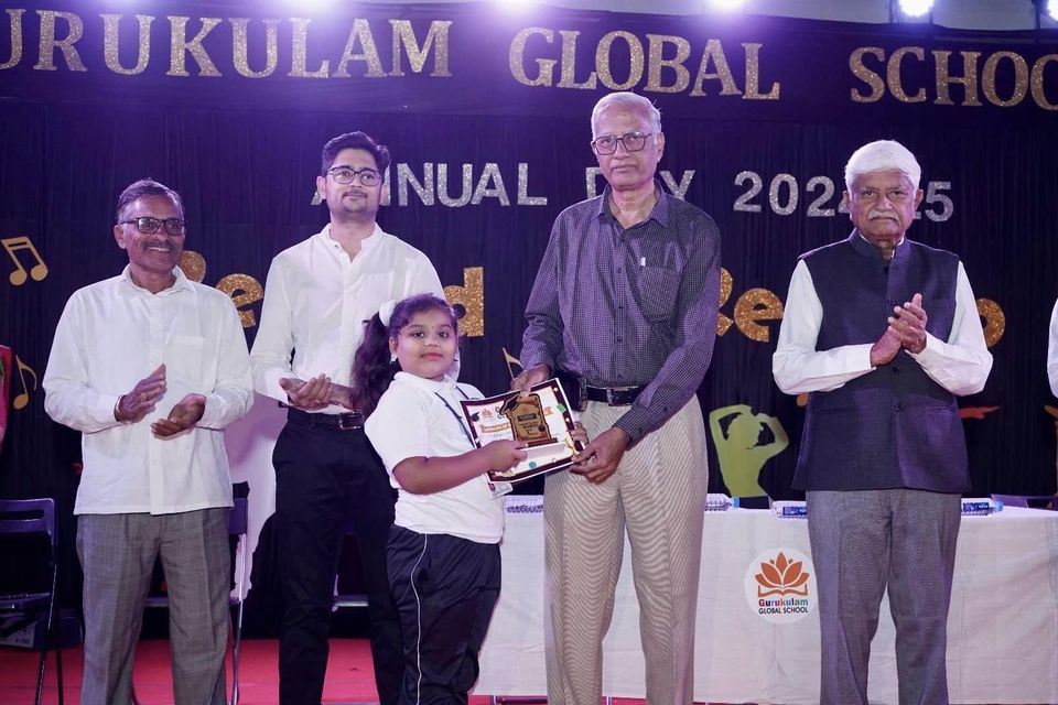 Guests on the dais present a memento to a student at Annual Day 2024-25