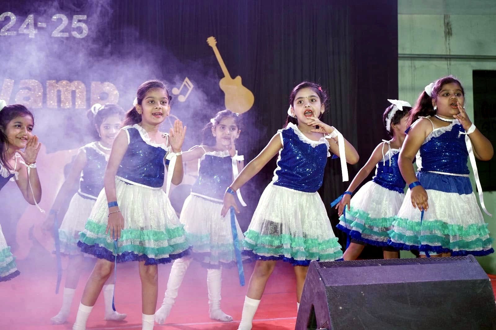 Junior girls in blue and white on the Annual Day stage