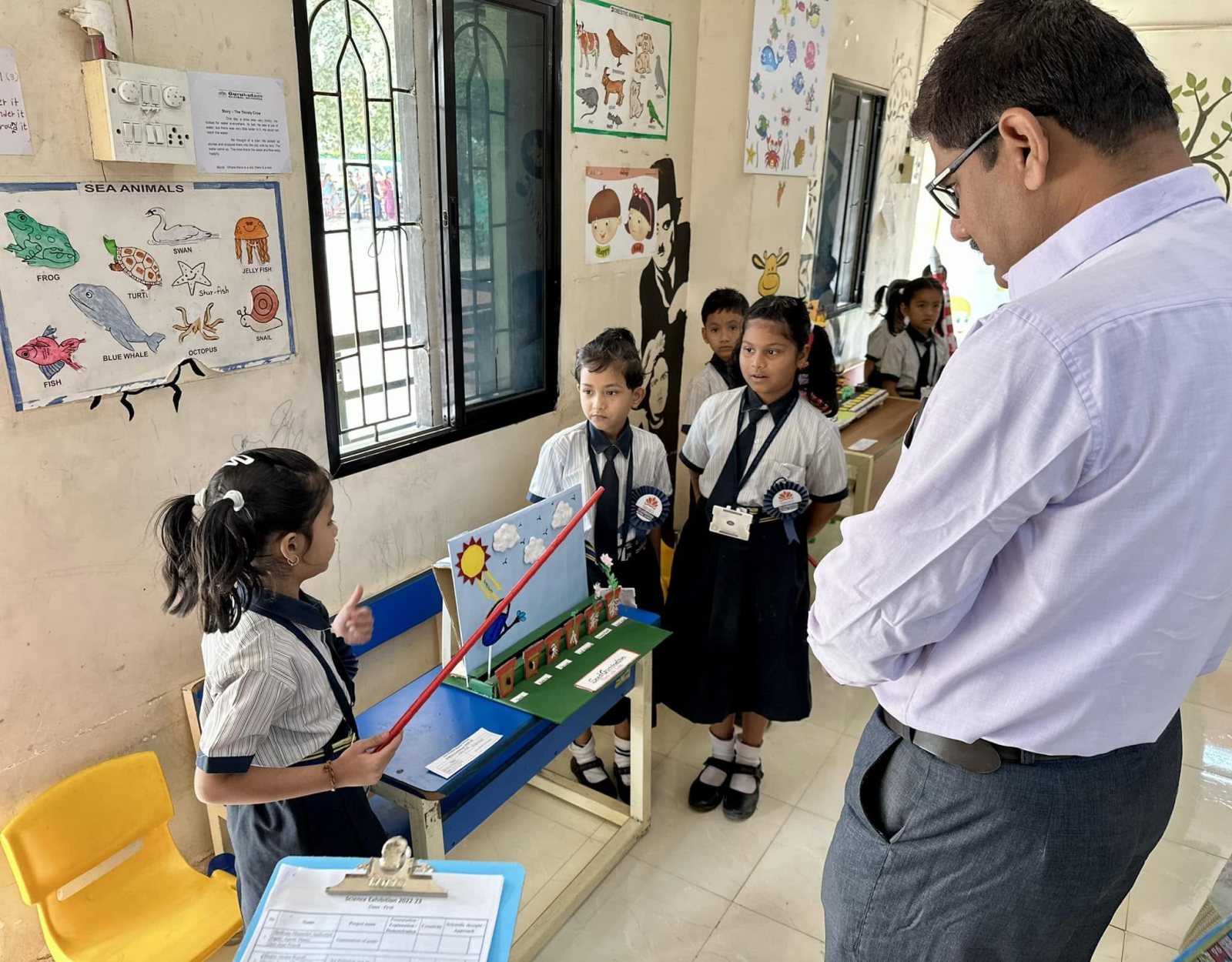 Young students walk a visitor through their model