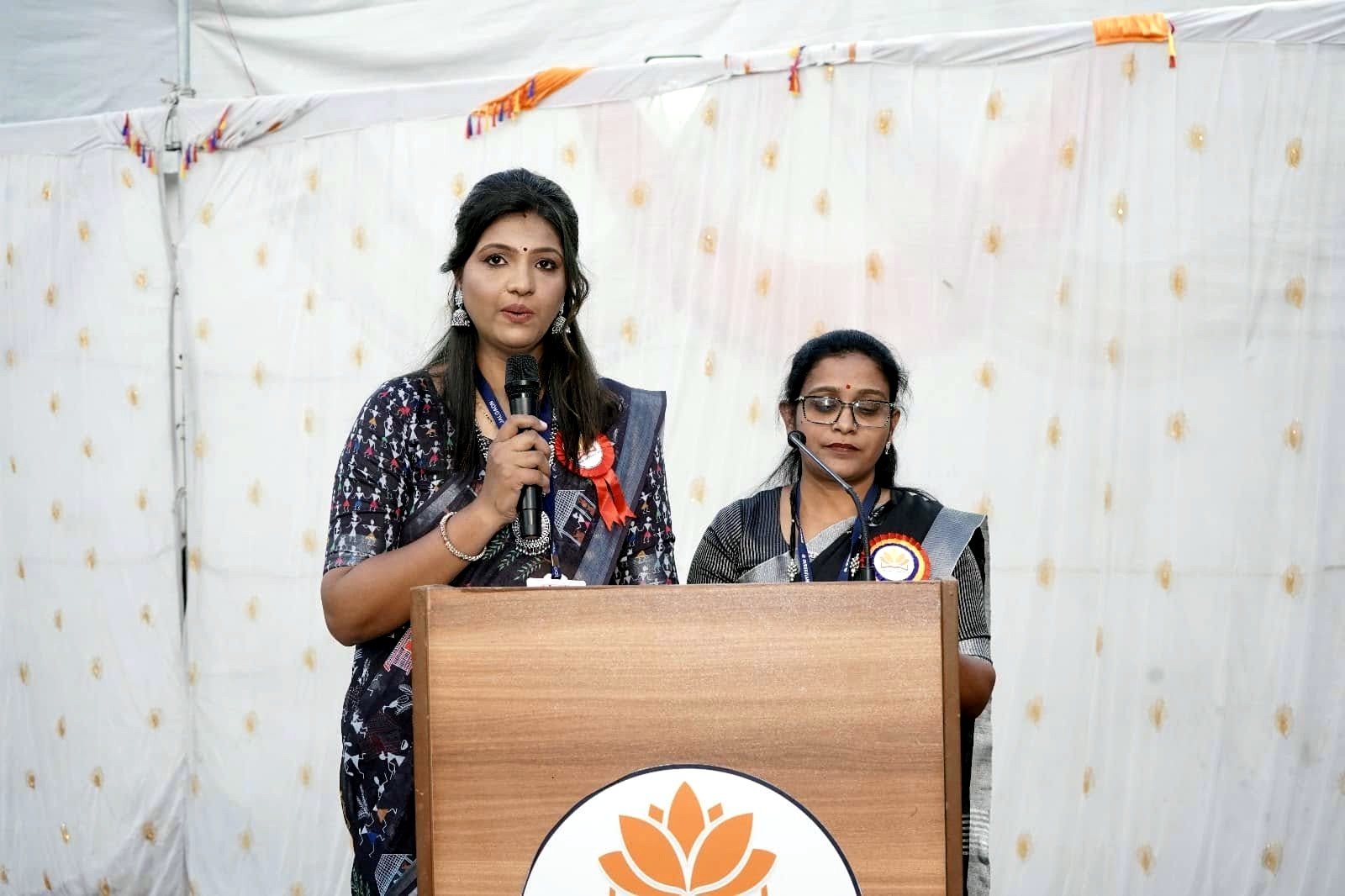 The compere and the Principal at the podium